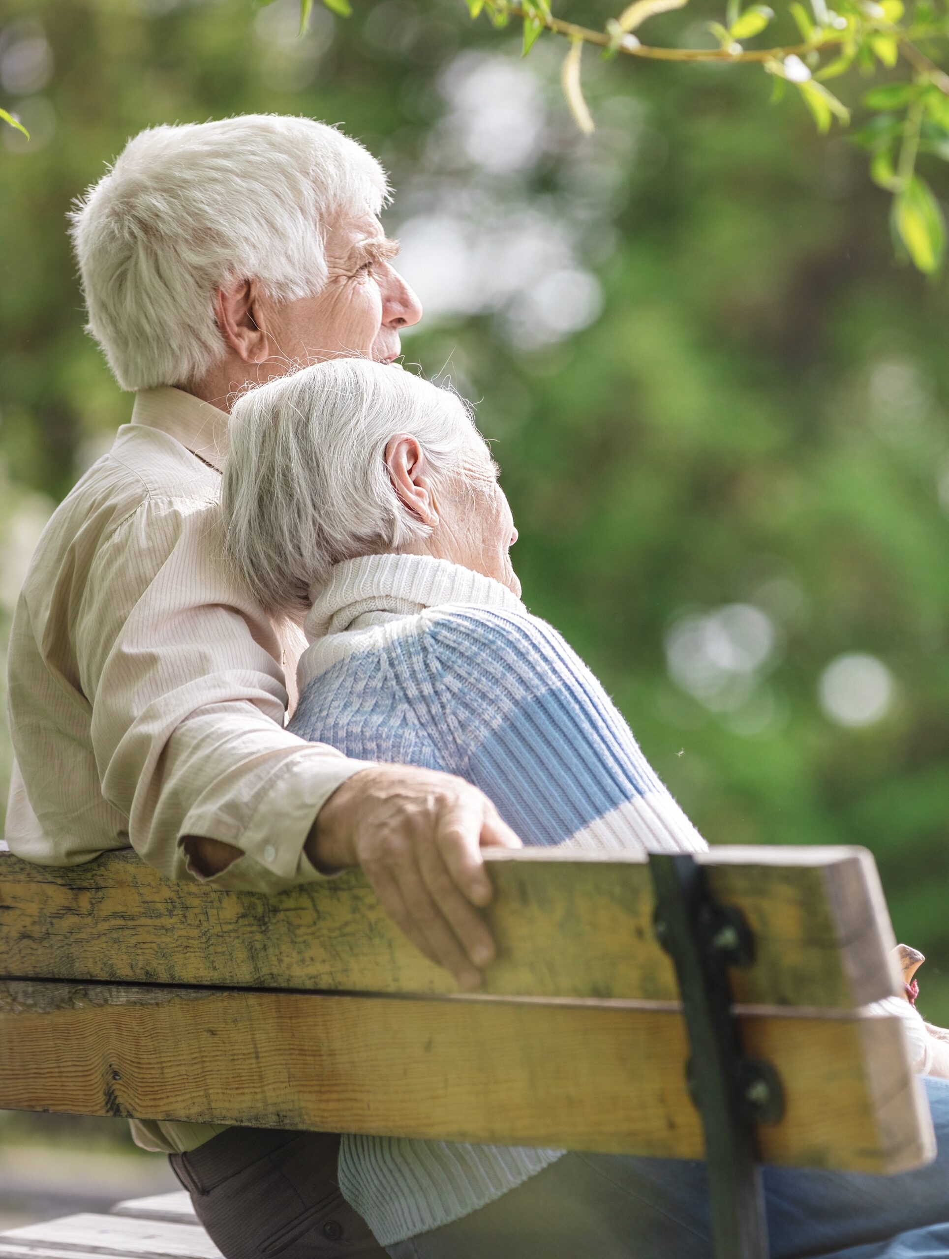 Elderly couple resting on a bench in the park